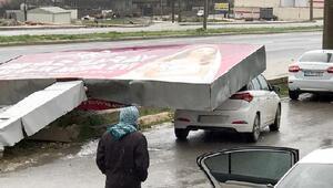 Reklam tabelası fırtınada otomobilin üzerine devrildi